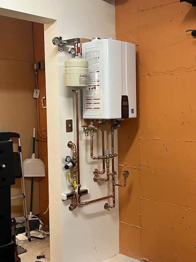 Plumbing technician inspecting water heater connections in South Park